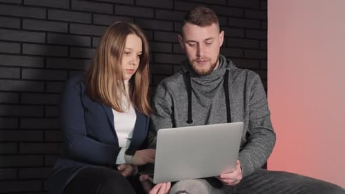 Young Adults Working on Laptop in Modern Office