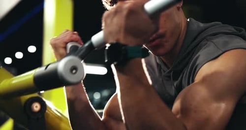 Muscular Man Works Out in Gym on Equipment