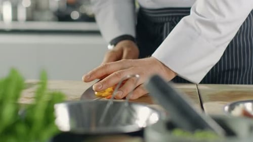 Close-up of a Chef Masterfully Cutting Colorful Vegetables on Cutting Board and Putting them Into