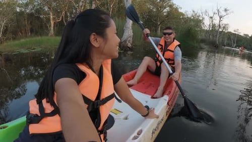 Couple kayaking on a calm river surrounded by nature