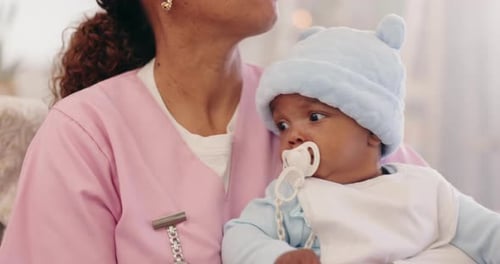 Caregiver Holding a Baby with Pacifier Indoors