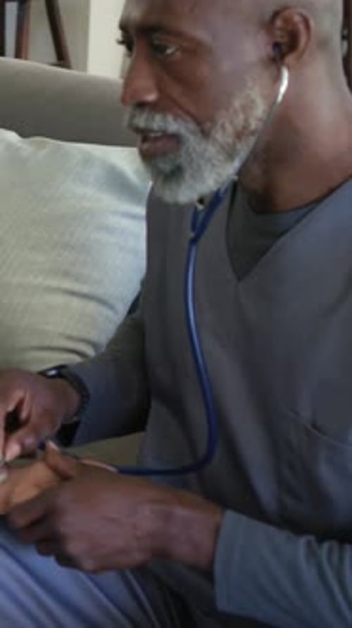 Vidéo verticale : vérification de l'état du pouls dans un gommage à l'aide d'un stéthoscope après que le patient a posé son bras sur le canapé