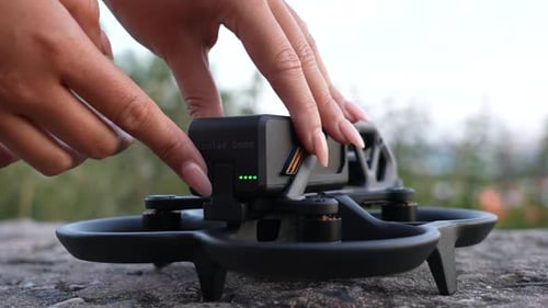 Turning on FPV Quadcopter Drone, Close Up of Hand on Power Button and LED Indicator of Battery Volum