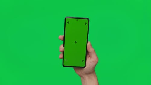 Male Hand Holding a Smartphone with Vertical Green Chroma Key Screen Isolated on Green Mobile Phone