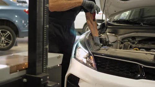 Man Repairing Car Engine in Garage