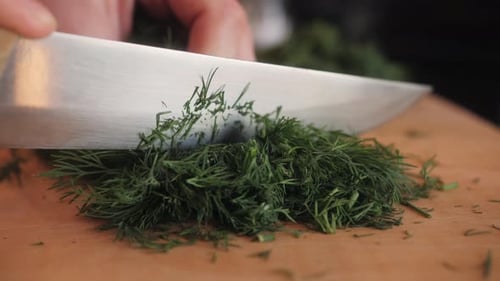 Cutting Dill Chef Cut Dill with Knife on a Wooden Board Close Up at Home