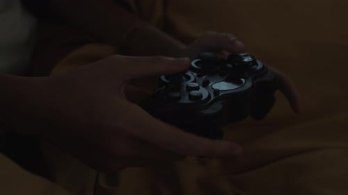 Hands Holding Gaming Controller While Playing Video Game