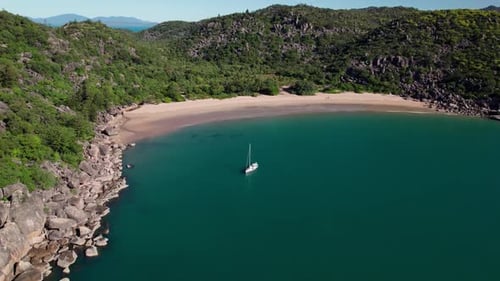 approaching drone shot of a boat on radical bay beach in Magnetic Island during a beautiful sunny
