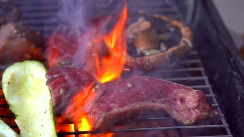 Making barbecue in grill with flames and smoke