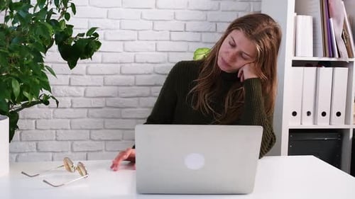 Tired Woman Working at Computer in Office