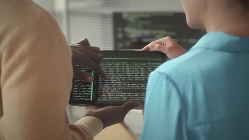 Two Programmers Discussing Code on Digital Tablet