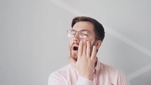 Man Applying Facial Moisturizer in Pink Shirt