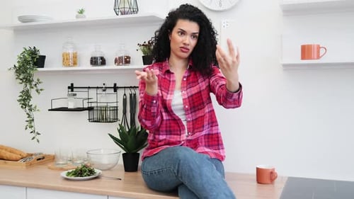 Woman Using Smartphone for Video Call in Kitchen