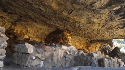 Sandstone Walls Of Cave Dwellings At Walnut Canyon By Trail Path. Follow Shot Left
