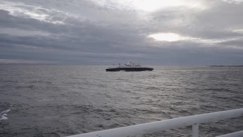 view on ferry in sea from other ferry in norway during cludy day in storm