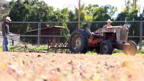 Cowboys Starting up Tractor Harrow Arena Plowing Field