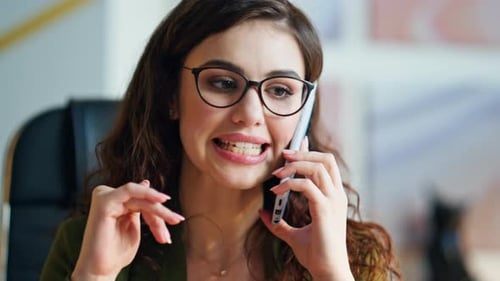 Worried businesswoman gesturing during dissatisfied cellphone conversation at office