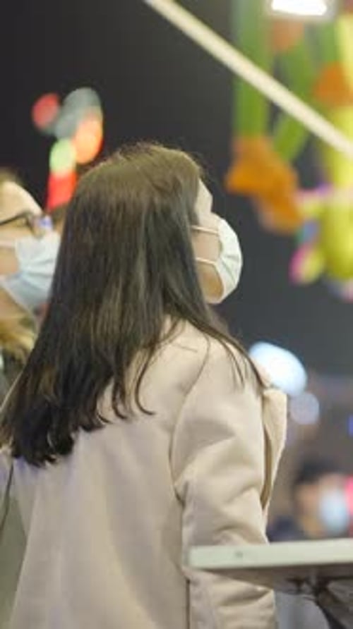 Profile of Women in Protective Mask Buying Food From a Street Truck at Night in Spain