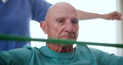 Senior Man Using Stretch Band with Physical Therapist