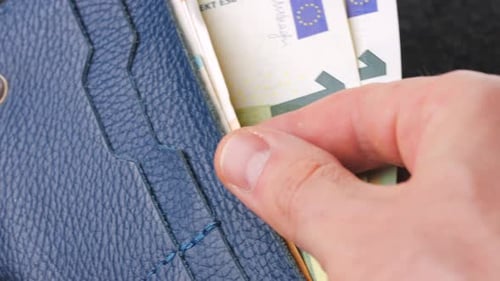 A Closeup View of Cash Being Stored in a Blue Wallet for Financial Purposes