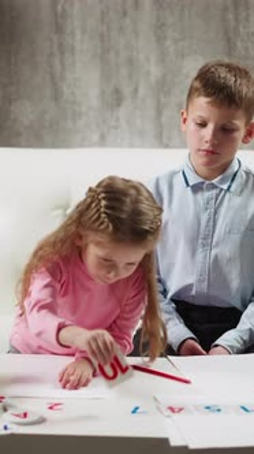 Schoolgirl Shows Digit Ten to Camera Near Brother on Sofa