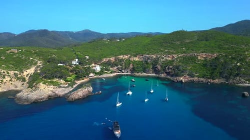 Sailboat and yachts anchor at Ibiza blue water bay Gorgeous aerial view flight drone