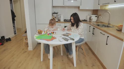 Mother and Daughter Drawing Together at Kitchen Table