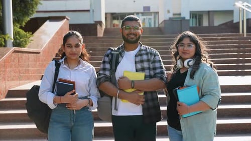 Three Indian Students Posing in Front of University Looking at Camera and Smiling