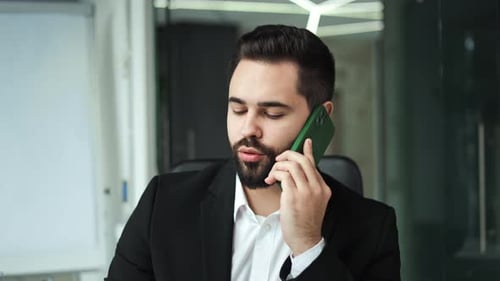 Man in Suit Talking on Cell Phone Indoors