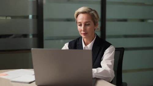 Professional Woman Working at Laptop in Modern Office