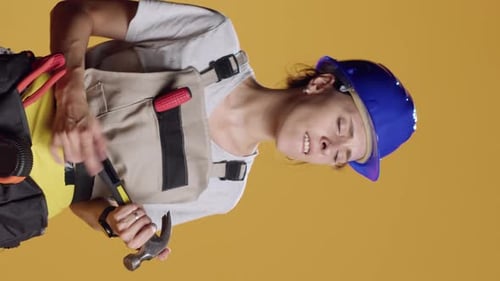Vertical Video Portrait of Silly Contractor Playing Air Guitar with Hammer
