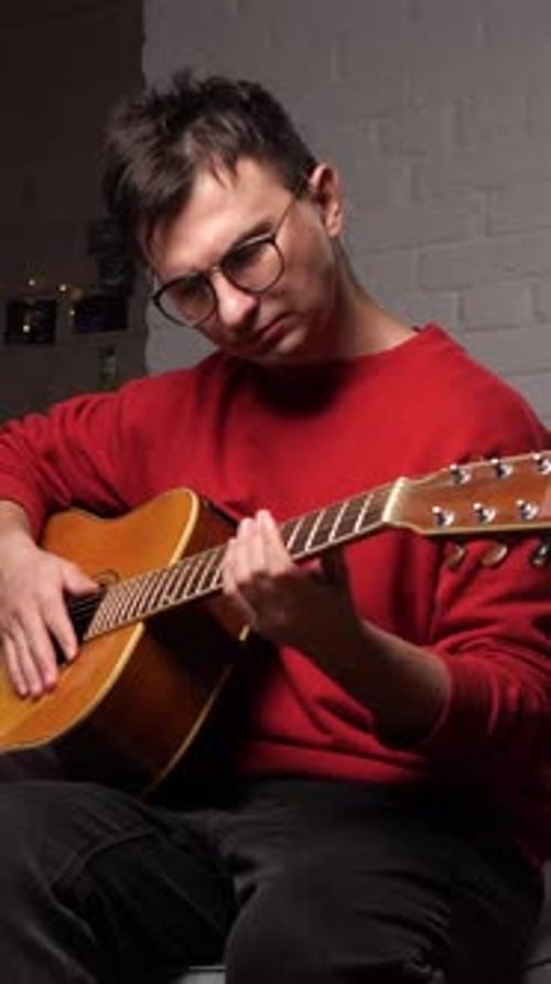 Man Plays Acoustic Guitar at Home in Vertical Video