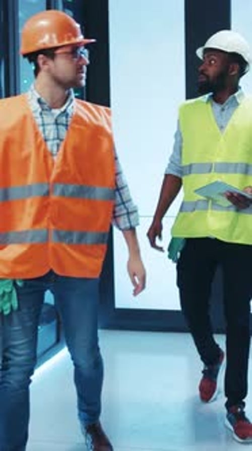 Technicians Wearing Safety Vests are Diligently Working in a Modern and Wellequipped Facility