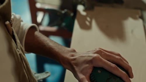 Young Adult Sanding Wood with Power Tool