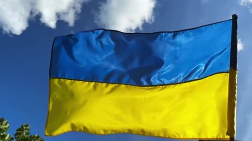 Flag of Ukraine Waving Against Blue Sky