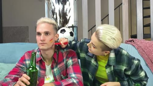 Jovem casal se preparando para torcer pela seleção espanhola de futebol em casa