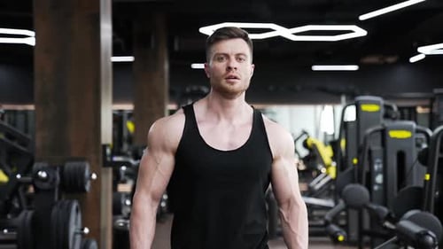 Um atleta bonito caminha no centro de fitness.