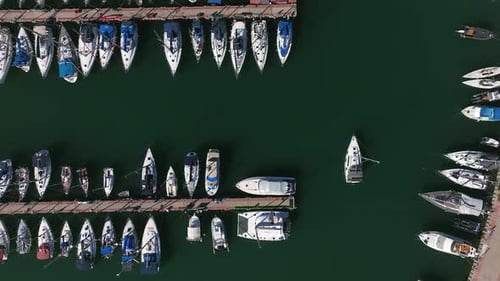 Luftbild eines kleinen Segelbootes, das langsam einen Yachthafen verlässt