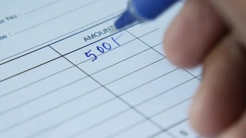 Um homem escreve o pagamento devido em um formulário de papel