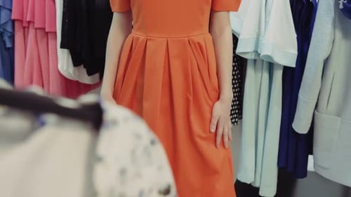 Closeup de uma jovem atraente experimentando um vestido em uma loja de moda