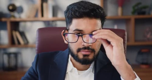 Indian Businessman Wearing Glasses Looking at Camera Posing in Office.