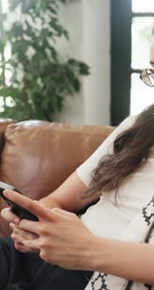 Woman Relaxing on Couch Using Mobile Phone Indoors