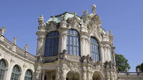A Grand White Building with Statues and Large Windows Stands Out