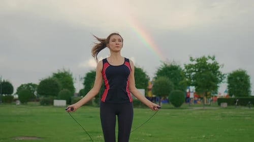 Woman Exercising with Jump Rope Outdoors in Park