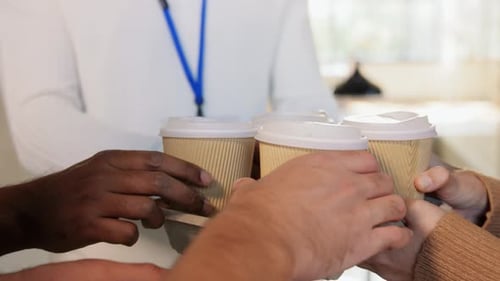 Business people enjoying takeaway coffee together at the office in slow motion