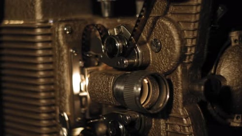 Close up on a vintage 8mm Projector with film running through it 4K