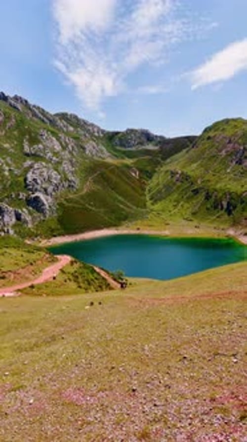 Beautiful turquoise lake located in the mountains. A couple stands watching the wonderful scenery.