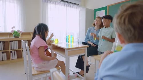 Adorable student learn with teacher in classroom at elementary school.