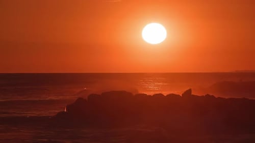 Dramatic Waves Crashing at Sunset on Rocky Coast