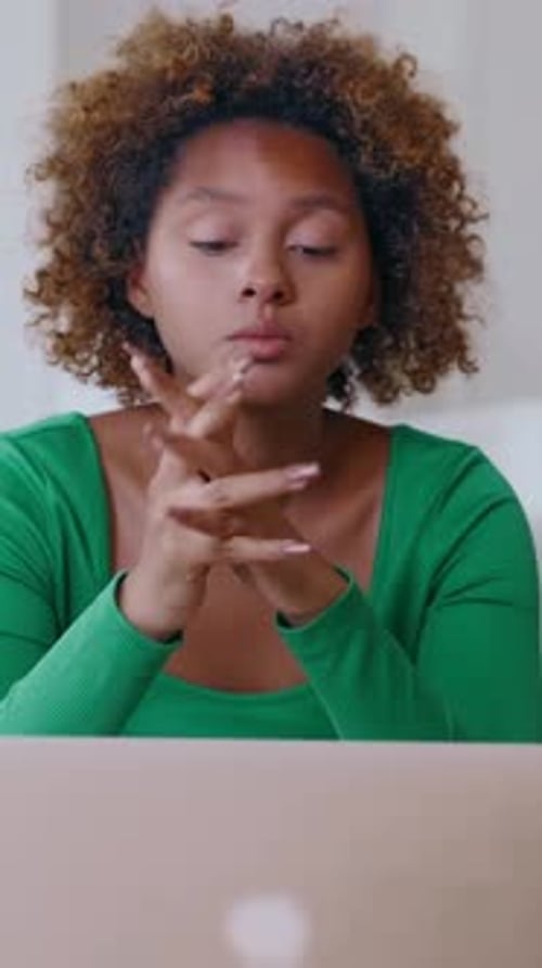 Woman looks stressed and overwhelmed in front of laptop